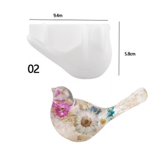 May include: A white silicone mold shaped like a bird, measuring 9.4 inches long and 5.8 inches tall. The mold is shown next to a finished resin bird with dried flowers embedded inside.