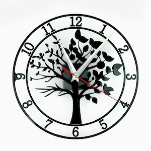 May include: A black and white clock with a tree design. The clock face has black Roman numerals and a silver hour hand and a red minute hand.
