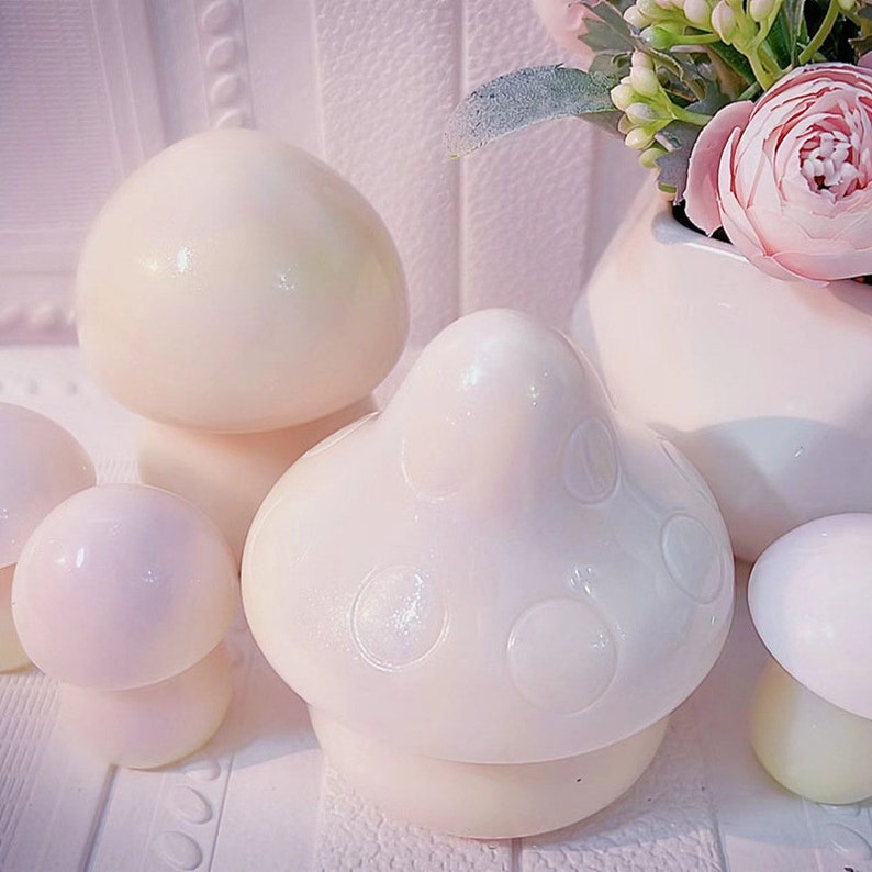 May include: A set of five white ceramic mushroom-shaped containers. The containers are different sizes and have a glossy finish. The largest container has a textured surface with small circles.