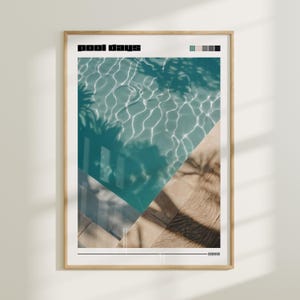 May include: A framed print with the text "pool days" in black lettering. The print features a photograph of a swimming pool with turquoise water and the shadows of palm trees cast on the water and surrounding tile.