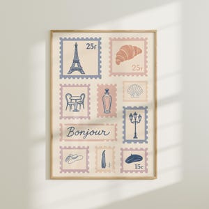 May include: A framed print featuring postage stamp designs with French themes. The stamps include an Eiffel Tower, croissant, cafe table, perfume bottle, seashell, street lamp, hat, perfume bottle, and beret. The word "Bonjour" is written across the center.