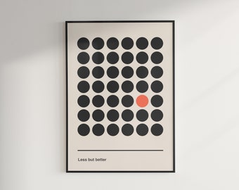 Op de afbeelding: Een ingelijst print met een minimalistisch ontwerp met een raster van zwarte cirkels met een enkele rode cirkel in het midden. De tekst "Less but better" is onder het raster gedrukt.