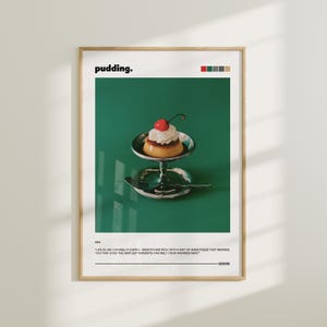 May include: A poster with a green background and a quote about life being like caramel pudding. The poster features a photo of a small, white pudding with a red cherry on top, sitting on a silver stand.