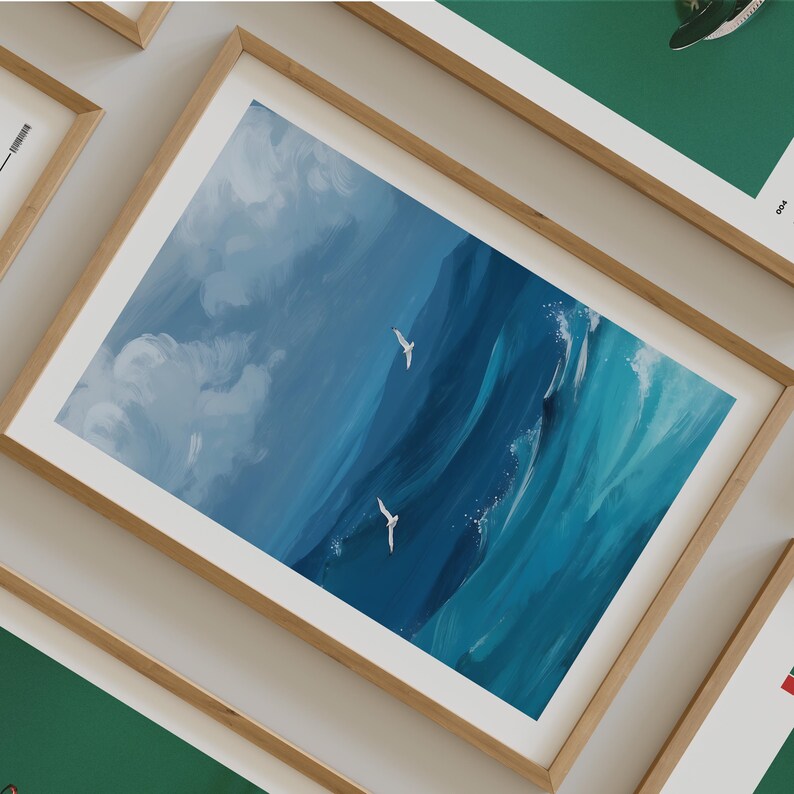 Puede incluir: Una impresi&oacute;n enmarcada de un paisaje mar&iacute;timo con nubes blancas y agua azul. Tres p&aacute;jaros blancos vuelan sobre el agua.
