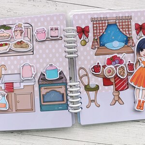 Pu&ograve; includere: Un libro di feltro colorato con una variet&agrave; di immagini, tra cui una scena di cucina, una scena di sala da pranzo e una bambola. Il libro ha una rilegatura a spirale ed &egrave; perfetto per i bambini piccoli.