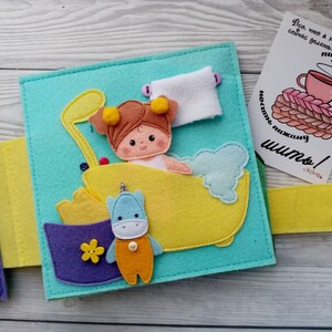 May include: A felt book for children with a page showing a girl in a bathtub with a unicorn toy. The text on the page reads "Все, что я хочу сейчас делать: пить кофе носить пижаму шить!"
