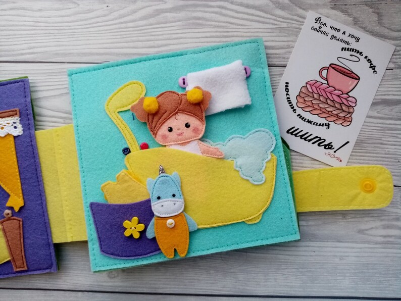 May include: A felt book for children with a page showing a girl in a bathtub with a unicorn toy. The text on the page reads "Все, что я хочу сейчас делать: пить кофе носить пижаму шить!"