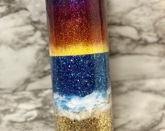 Vaso con brillo de playa y océano al atardecer