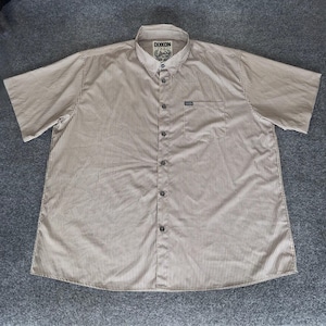 May include: A short-sleeved button-down shirt with vertical brown and white stripes. The shirt has a chest pocket and a collar. The brand name "DIXON" is visible on the collar.