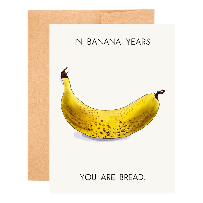 May include: A greeting card with a yellow banana with brown spots and the text "In banana years you are bread."