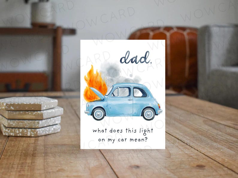 May include: A greeting card with a watercolor illustration of a light blue car on fire. The text reads "dad," and "what does this light on my car mean?" The card is on a wooden surface.