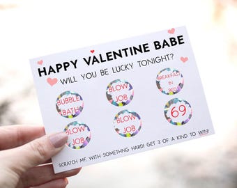 May include: A white card with the text "Happy Valentine Babe Will You Be Lucky Tonight?" and colorful scratch-off circles with phrases like "Bubble Bath", "Blow Job", "Breakfast in Bed", and "69".