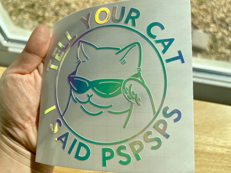 K&ouml;nnte beinhalten: Ein holografischer Aufkleber mit einer Katze, die eine Sonnenbrille tr&auml;gt, und dem Text "I said tell your cat PSPSPS".