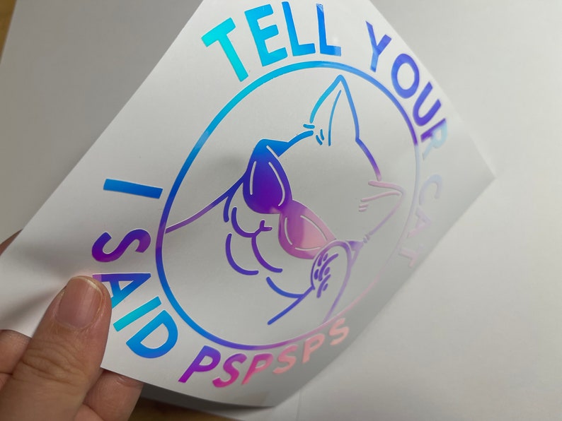 K&ouml;nnte beinhalten: Ein holografischer Aufkleber mit einem blauen, rosa und violetten Farbverlauf. Er zeigt eine Comic-Katze mit Sonnenbrille und dem Text "I said TELL YOUR CAT PSPSPS".