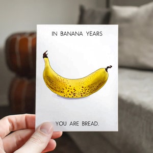 May include: A white card with the text "In banana years, you are bread." and a drawing of a yellow banana with brown spots.