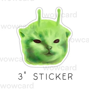 May include: A 3-inch sticker featuring a green alien cat with black eyes and antennae. The sticker has a white border and the word "STICKER" is printed in black below the image.