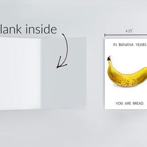 May include: A greeting card with a yellow banana with brown spots on a white background. The text on the card reads "In banana years, you are bread." The card measures 4.25 inches by 5.5 inches.