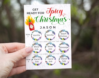 May include: A white card with the text "Get Ready for Spicy Christmas Jason" and a red and green chili pepper graphic. The card has a game board with nine colorful circles, each with a different activity written inside. The activities include "Vanilla", "Wash Dishes", "Blow Job", "Massage", and "Hand Job".