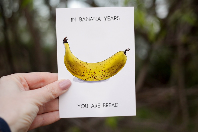 May include: A white card with the text "In banana years, you are bread." and a drawing of a yellow banana with brown spots.