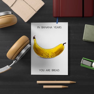 May include: A white card with the text "In banana years, you are bread." and a drawing of a yellow banana with brown spots.