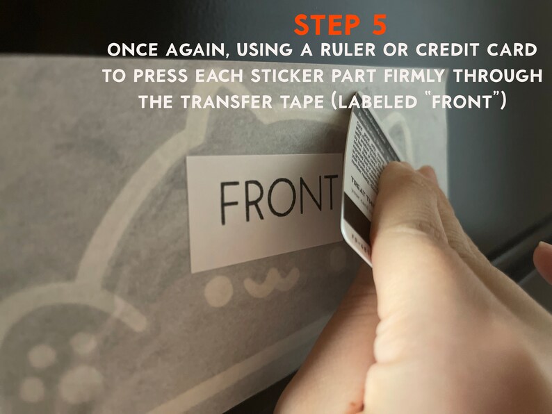 Puede incluir: Imagen que muestra la aplicaci&oacute;n de una pegatina. El texto "STEP 5" est&aacute; en la parte superior, seguido de instrucciones para presionar firmemente la pegatina. La palabra "FRONT" es visible en una etiqueta. Se utiliza una tarjeta de cr&eacute;dito.