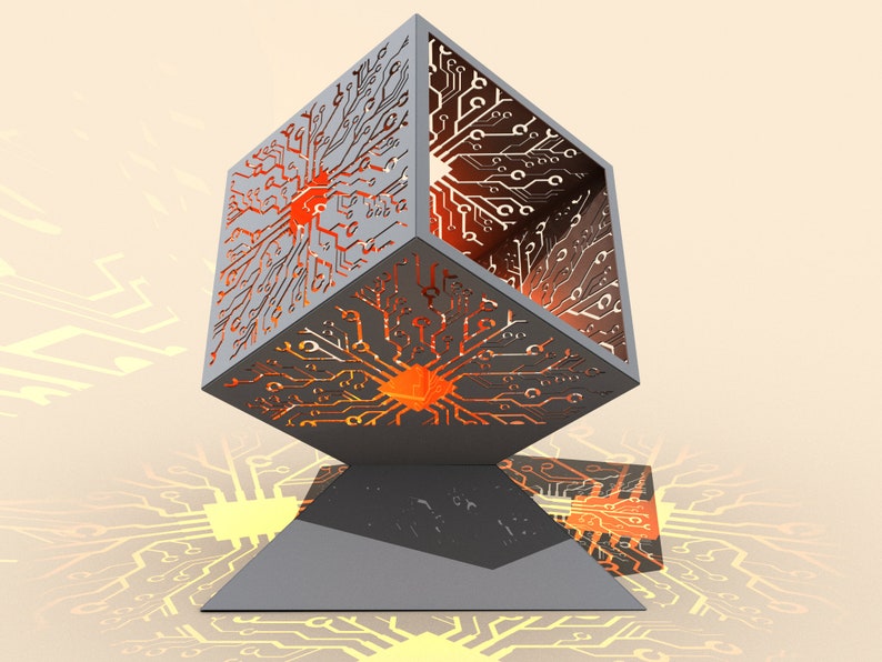 May include: A gray metal cube with a circuit board design cut out. The cube is lit from within, creating a warm orange glow. The cube is sitting on a gray triangular base.