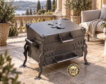 May include: A dark gray metal fire pit with a hinged lid featuring a fleur-de-lis cutout. The rectangular unit has ornate, curved legs, side handles, and a front drawer with a horizontal handle. A gold circular badge reads Digital Product DXF File.