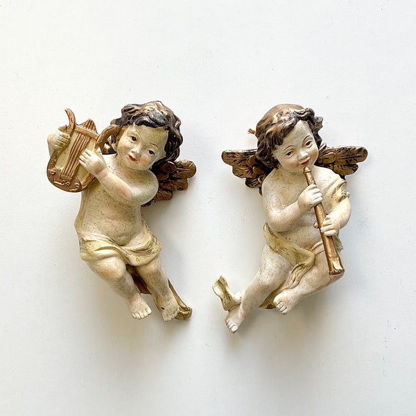 A pair of Vintage Putti cherub figurines with instruments, handpainted and gilded.