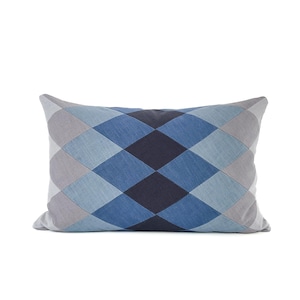 May include: A rectangular cushion with a geometric diamond pattern. The cushion features a patchwork design with various shades of blue and grey, creating a visually appealing contrast. The cushion is designed for home decor.