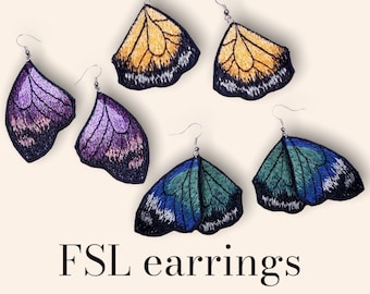 May include: Butterfly wing earrings in yellow, purple, and blue and green. The earrings are made with embroidery and have a silver hook.