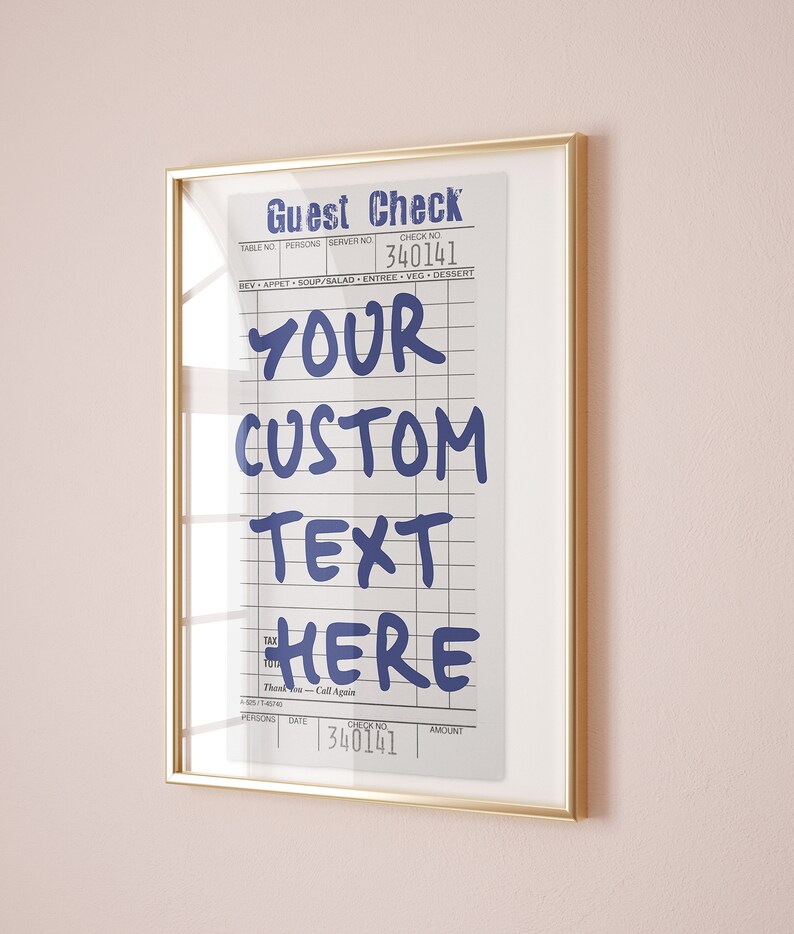 May include: A framed wall art print featuring a vintage-style guest check design with blue text that reads Guest Check, 340141, YOUR CUSTOM TEXT HERE, and Thank You - Call Again. The print is enclosed in a thin, metallic gold-colored rectangular frame.