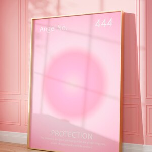 May include: A gold framed poster with a pink background and the text "Angel No. 444 PROTECTION The Universe and your spiritual guides are protecting you. Doors of opportunity will be opened."