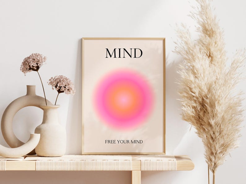 May include: A framed art print with the word "MIND" at the top and "FREE YOUR MIND" at the bottom. The artwork features a vibrant pink and orange gradient circle. Decorative vases and dried flowers are in the foreground.