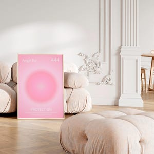 May include: A framed poster with a pink gradient background and a circle in the center. The poster has the text "Angel No. 444" at the top and "PROTECTION" in the center.
