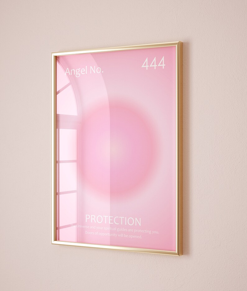 May include: A gold framed poster with a pink background and a white circle in the center. The text "Angel No. 444" is at the top of the poster. The text "PROTECTION" is at the bottom of the poster, along with the text "The universe and your spiritual guides are protecting you. Doors of opportunity will be opened."