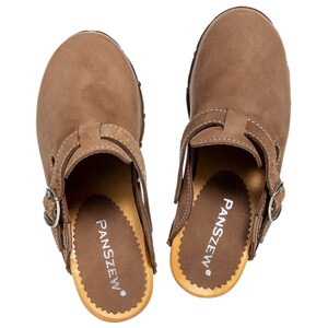 May include: A pair of brown leather clogs with a buckle strap. The clogs have a wooden sole with the brand name "PANSZEW" printed on the insole.