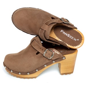 May include: Brown leather clogs with a buckle strap and wooden heel. The clogs have a brand name "PANSZEW" on the insole.