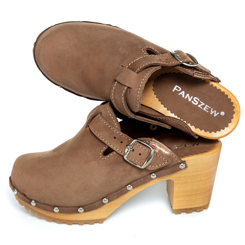 May include: Brown leather clogs with a buckle strap and wooden heel. The clogs have a brand name "PANSZEW" on the insole.