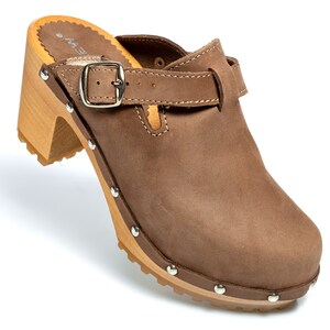 May include: Brown leather clog with a buckle strap and a wooden heel. The clog has a studded sole.