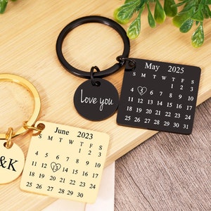 Peut inclure: Deux porte-clés dorés et noirs avec des dates de calendrier gravées et les mots "Love you" et "M&K".