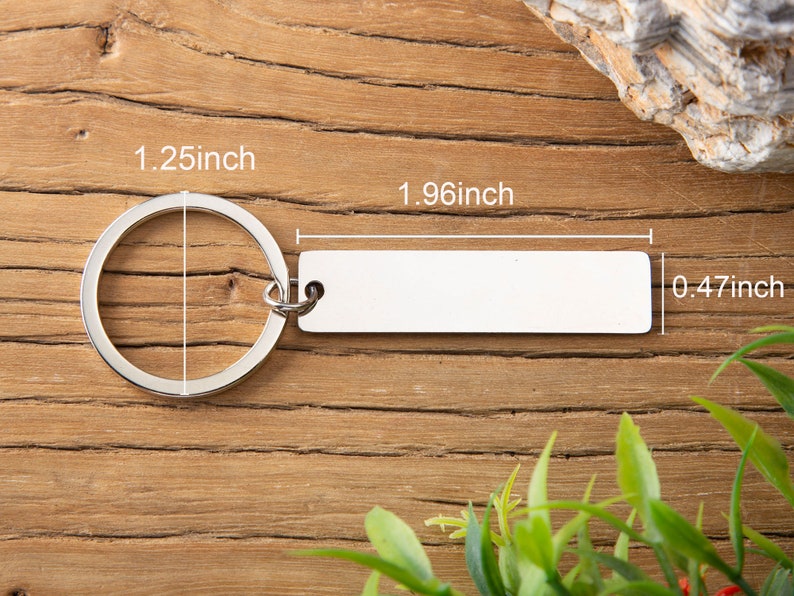 May include: Silver keychain with a 1.25 inch ring and a 1.96 inch by 0.47 inch rectangular tag.