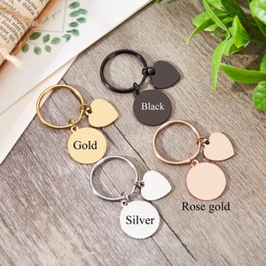 May include: Four keychains with different colored metal finishes: gold, black, rose gold, and silver. Each keychain has a round charm with the color name and a heart-shaped charm.