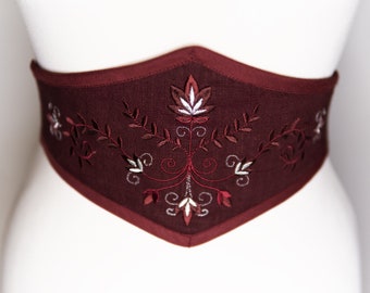 May include: A burgundy linen belt with a white and burgundy floral embroidery design.