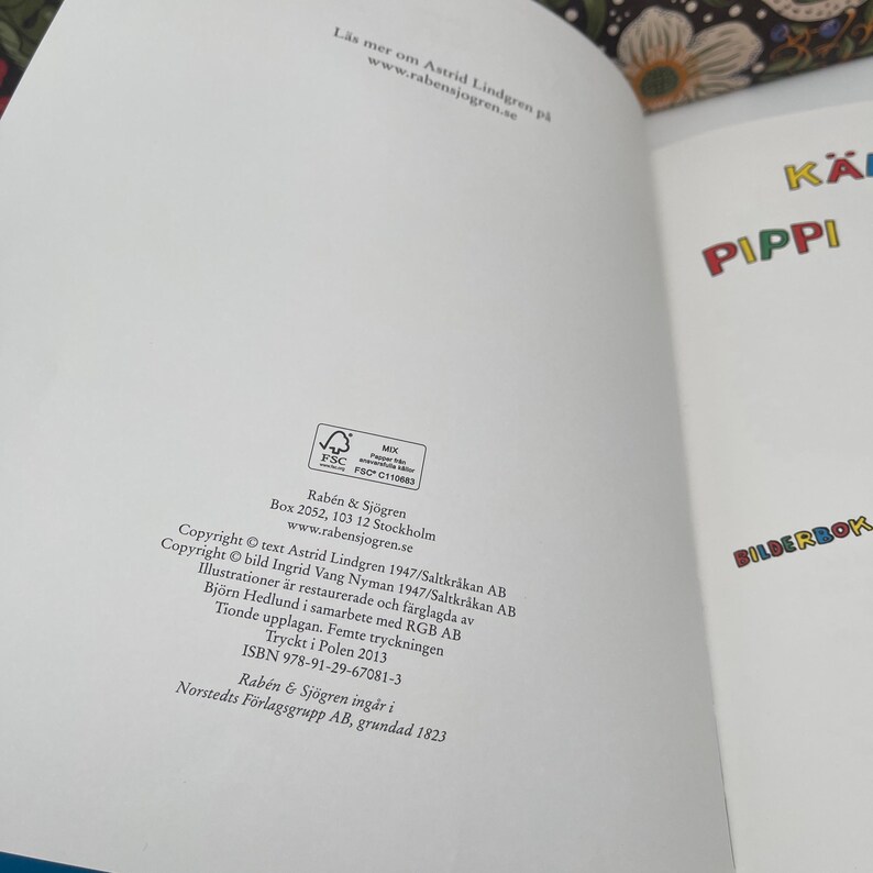 May include: Open book with the title "PIPPI" in colorful letters. The page includes text in Swedish and copyright information. The book is a children's picture book, with the publisher's logo and address visible.
