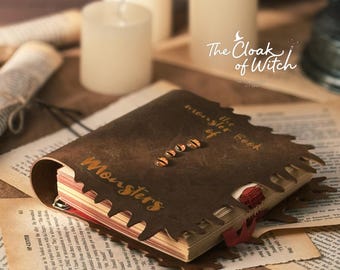 May include: A brown leather-bound book titled "The Monster Book of Monsters" with a unique saw-tooth edge design. The book is open with a red ribbon bookmark, surrounded by aged paper and candles.