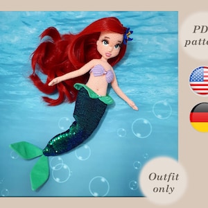 May include: Crocheted mermaid doll with red hair, a purple seashell bra, and a green and blue sequined tail. The doll is floating in blue water with bubbles. The text "PDF pattern" and "Outfit only" is visible in the image. The image also includes the American and German flags.