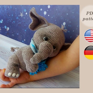Puede incluir: Juguete de peluche de elefante gris tejido a crochet con una bufanda azul y blanca. Patrón PDF disponible en inglés y alemán.