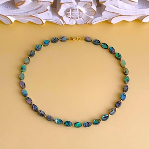Paua Abalone (naturlig pärlemor från abalone) oval 10x6x3mm skimrande med gyllene minipärlor