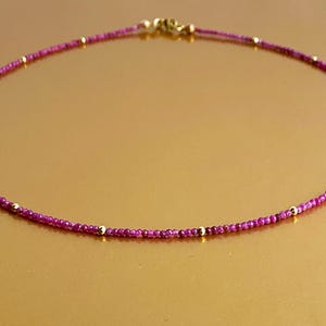 Op de afbeelding: Een delicate ketting gemaakt met kleine roze kralen en gouden accenten. De ketting is ongeveer 45 cm lang.