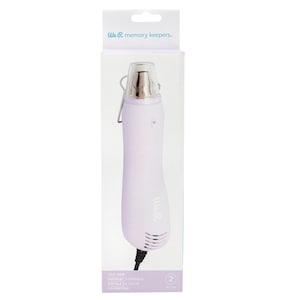 May include: A purple heat gun with a clear nozzle and a black cord. The packaging says "We R memory keepers." and "Heat Gun, Pistolet Thermique, Pistola de Calor, Hegpistole".